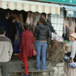 Tibet, Lhasa: women dressed in different attire  shopping at a