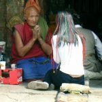 Tibet: Lhasa - young woman consulting a monk