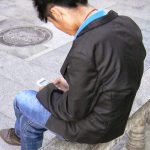 Tibet: Lhasa - youth with cell phone;  most young people