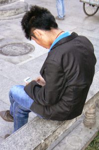 Tibet: Lhasa - youth with cell phone;  most young people