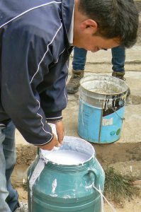 Tibet: Lhasa - adding milk to white paint to color