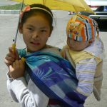 Tibet: Lhasa - young girl with her baby sister;  spots