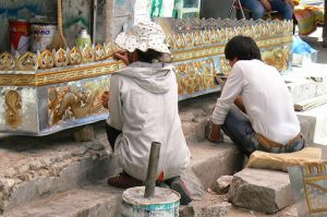 Tibet: Lhasa - metalworkers applying paint  to a decorative awning