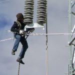 Tibet: worker installing new power lines  (about 75 feet above