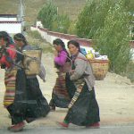 Tibet: rural women walking home with supplies.