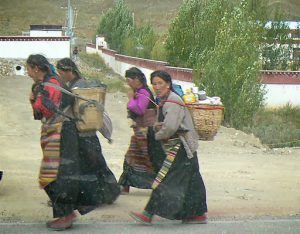 Tibet: rural women walking home with supplies.
