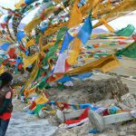 Tibet: Michael and Tenzin and prayer flags at Namtso Lake (Sky