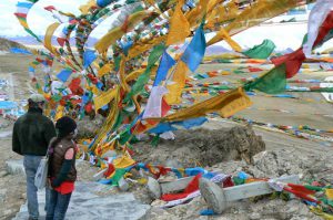 Tibet: Michael and Tenzin and prayer flags at Namtso Lake (Sky