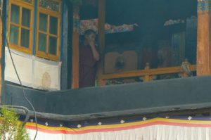 Tibet: Lhasa Monk watching the crowds of visitors to Jokhang.