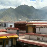 Tibet: Lhasa Monk, mountains and smoke at Jokhang Temple.