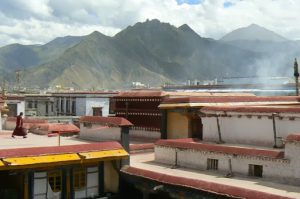 Tibet: Lhasa Monk, mountains and smoke at Jokhang Temple.