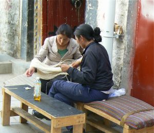 Tibet: Lhasa Two women winding threads of wool.