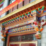 Tibet: Lhasa Ornate door cornice painted with  typical color pattern for
