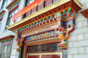 Tibet: Lhasa Ornate door cornice painted with  typical color pattern for