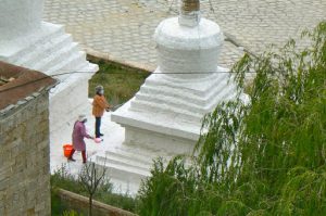 Tibet: Lhasa - Pabonka Monastery.  Women throw the milky paint