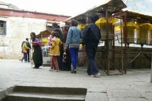 Tibet: Lhasa - Sera Monastery. Visitors spinning prayer wheels before  they