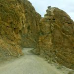 Tibet - narrow dirt road through a rocky pass.