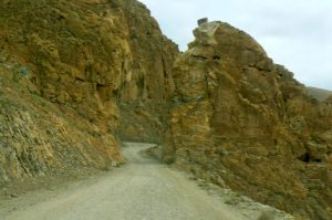 Tibet - narrow dirt road through a rocky pass.