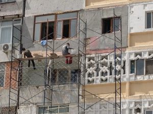 Uzbekistan: Tashkent Repairing the multi-pattern facade of an old apartment building.