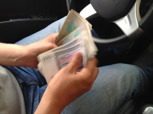 Uzbekistan: Tashkent Black market money exchanging in a taxi.  Drivers always