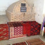Uzbekistan: Bukhara Telpak Furushon covered bazaar shop with a old sarcophagus.