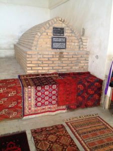 Uzbekistan: Bukhara Telpak Furushon covered bazaar shop with a old sarcophagus.