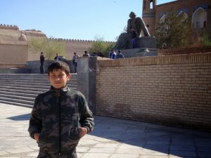 Uzbekistan: Khiva Young boy in front of a statue of the