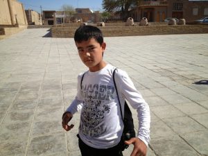 Uzbekistan: Khiva Young student showing off his shirt.
