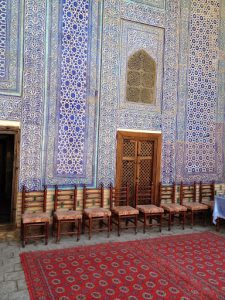 Uzbekistan: Khiva Glazed tile wall and woven carpet of an aiwan