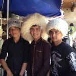 Uzbekistan: Khiva Three young men trying on souvenir hats.