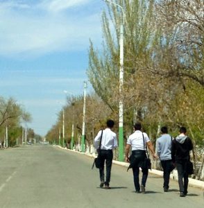 Uzbekistan: Nukus Student walking home; the standard school uniforms are white