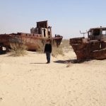 Uzbekistan: Muynak Michael at Aral Sea dry bed with rusting boats.