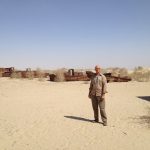 Uzbekistan: Muynak Richard at Aral Sea dry bed with rusting boats.