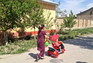 Uzbekistan: Fergana Valley, Rishton A stylish villager takes her child