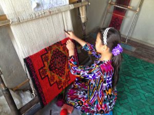 Uzbekistan: Fergana Valley, Rishton Another child is learning carpet making, dressed