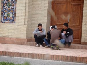 Uzbekistan: Kokand City Guys on steps to mosque. (raindrops on car