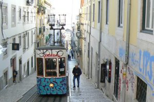 Portugal, Lisbon: graffiti-covered trolley on narrow street