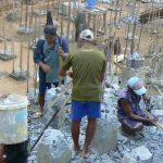 Burma, Rangoon:construction site; workers removing old cement piers by hand with sledge