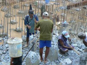 Burma, Rangoon:construction site; workers removing old cement piers by hand with sledge