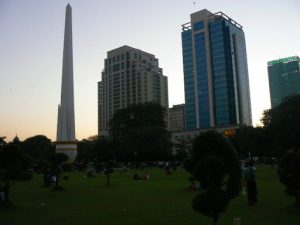 Burma, Rangoon: Mahabandoola Garden park; Independence Monument (L) and office buildings