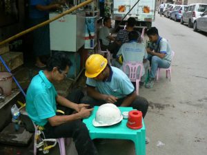 Burma, Rangoon: workers break time with phones